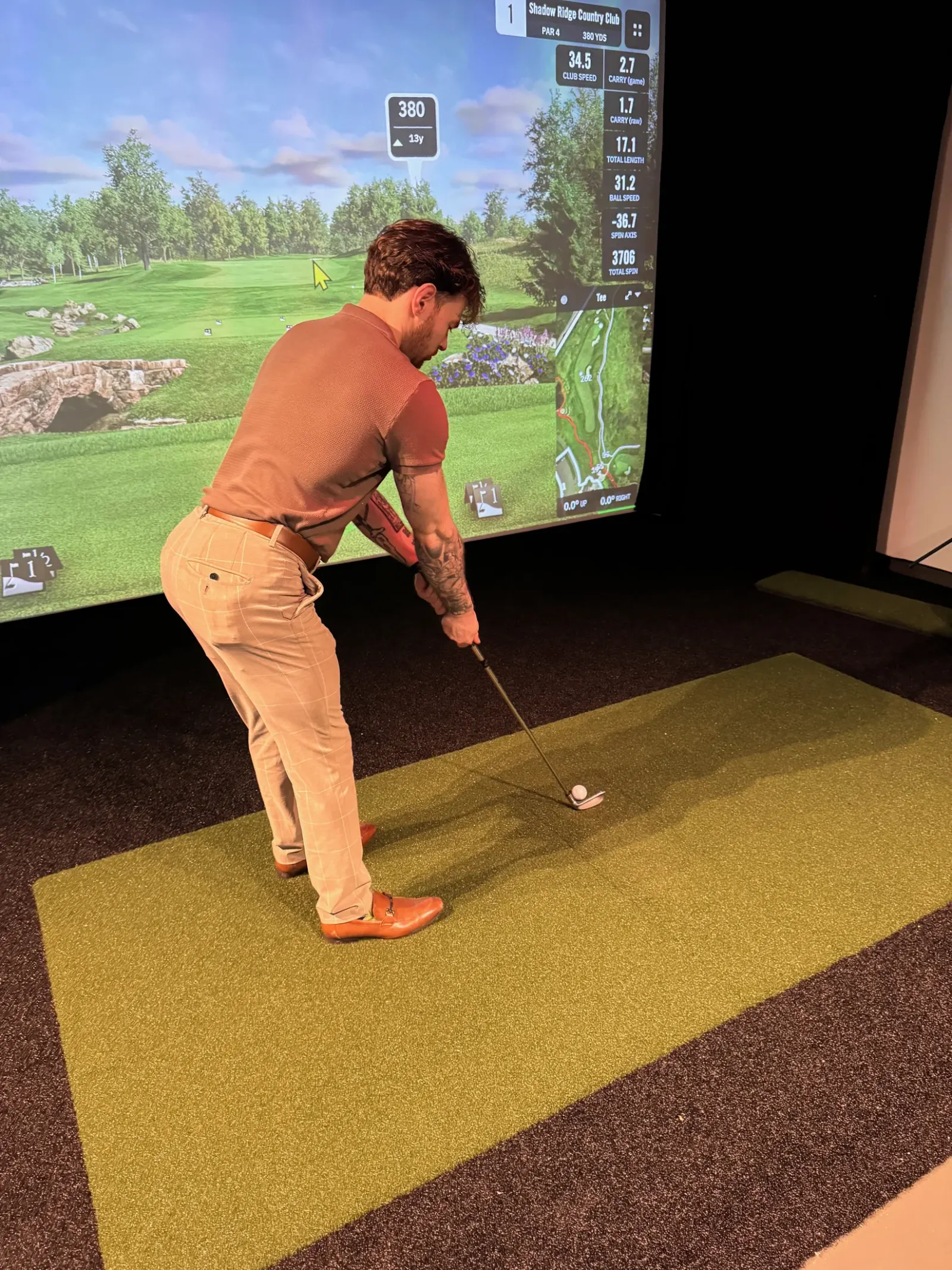 A guest playing in the Sigaro golf simulator